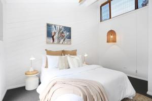 a white bedroom with two beds in it at Hawks Nest Hideaway in Hawks Nest
