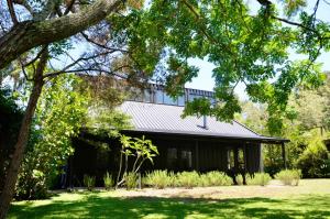 a house with a metal roof and a yard at Hawks Nest Hideaway in Hawks Nest