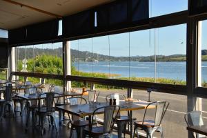 a restaurant with tables and chairs and a view of the water at Rosevears Riverview Hotel in Rosevears