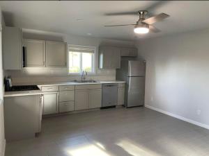 a kitchen with white cabinets and a ceiling fan at New, Fun-Size Benbow House! in Garberville
