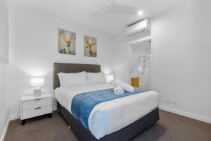 a bedroom with a large bed with a blue blanket at Cabarita Beachside - Hosted by Holiday Management in Cabarita Beach