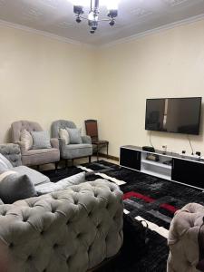 ein Wohnzimmer mit einem Sofa und einem Flachbild-TV in der Unterkunft Uthiru Heights in Nairobi