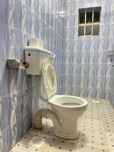 a bathroom with a toilet in a blue tiled wall at Uthiru Heights in Nairobi