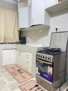a kitchen with a stove and white cabinets at Uthiru Heights in Nairobi