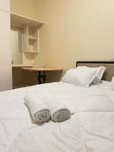 ein weißes Bett mit zwei Handtüchern darüber in der Unterkunft Uthiru Heights in Nairobi