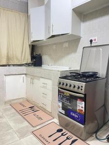 a kitchen with a stove and white cabinets at Uthiru Heights in Nairobi