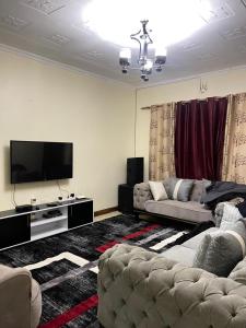 a living room with a couch and a flat screen tv at Uthiru Heights in Nairobi
