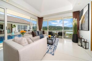 a living room with a white couch and large windows at Stunning 5 bedrooms Villa with Panoramic Sea View in Por Bay