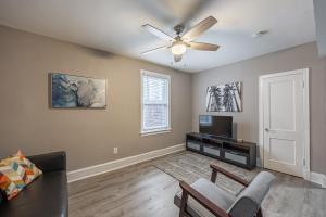 a living room with a ceiling fan and a tv at Modern Updated Condo Near Downtown in Washington