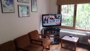 a living room with a tv and a chair and a table at Edelweiss Hotel in Platres