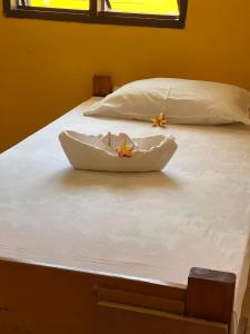 two beds with white sheets and flowers on them at Mana Backpackers and Dive Resort in Mana Island