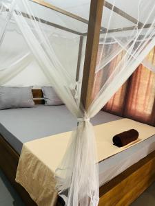 a bed with a mosquito net on top of it at Avalon in Weligama