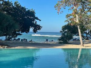 een uitzicht op een strand met stoelen en de oceaan bij Irie Vibes Ocean View in Negril