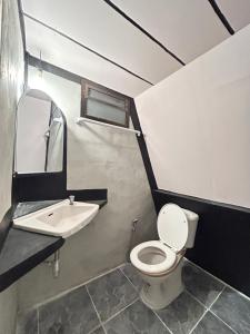 a bathroom with a toilet and a sink at บ้านริมน้ำ สำหรับครอบครัว in Buriram