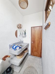 El Paredón Buena VistaにあるVilla Makai 2 Blueのバスルーム(シンク、木製のドア付)