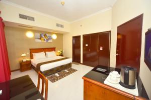 a hotel room with a bed and a desk at Nejoum Al Emarat in Sharjah