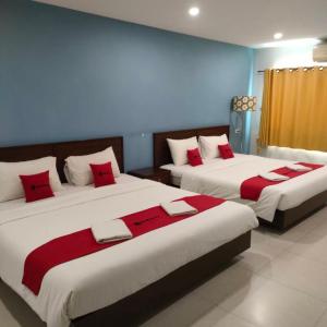 - 2 lits dans une chambre avec des oreillers rouges dans l'établissement Happy by Jan guesthouse, à Hua Hin