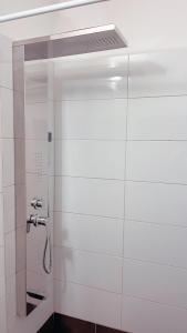 eine Dusche im Bad mit einer weißen Kachelwand in der Unterkunft Modern Apartment in The Heart of Athens Near Acropolis in Athen