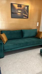 zieloną kanapę w pokoju ze ścianą w obiekcie Smart Lux Apartment A w Atenach
