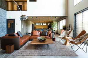 a living room with a couch and a table at Cairns House by SANA in Tateyama