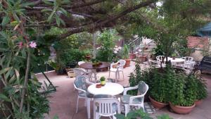 a patio with white tables and chairs and plants at Edelweiss Hotel in Platres