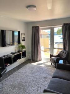 a living room with a couch and a television at Akaroa Village Inn in Akaroa