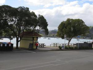 a picnic shelter next to a lake with trees at Akaroa Village Inn in Akaroa