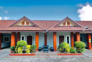 a house with a bench in front of it at Benwadee Resort Pattaya in Ban Pong