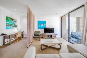 a living room with a couch and a table at Oaks Redcliffe Mon Komo Suites in Redcliffe