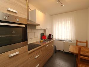 a kitchen with wooden cabinets and a large television at Property in Essen in Essen