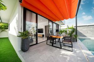 ラワイビーチにあるMango Hill Residenceの屋外パティオ(テーブル、椅子付)、プールが備わります。