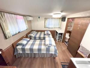 Habitación pequeña con 2 camas y lavamanos en SHINJUKU WARM VILLA I, en Tokio