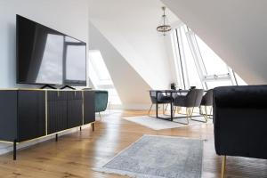 a living room with a tv and a dining table at My Perfect Penthouse in Vienna
