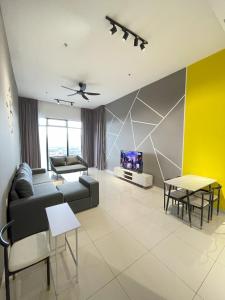 een woonkamer met een bank en een tv bij Penang Georgetown KT Home for 8 pax in George Town