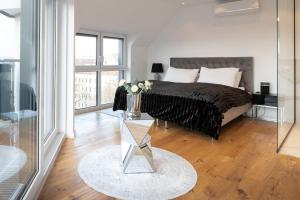 1 dormitorio con 1 cama y un jarrón de flores sobre una mesa en My Perfect Penthouse, en Viena