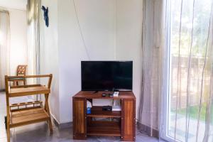 a television sitting on a table in a room with a window at villa Anthalo in La Saline les Bains