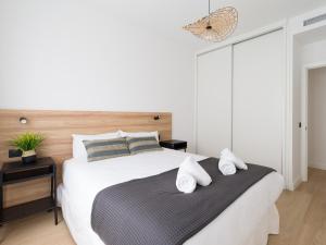 um quarto com uma grande cama branca e 2 almofadas em Pascal Home By CanariasGetaway em Las Palmas de Gran Canárias