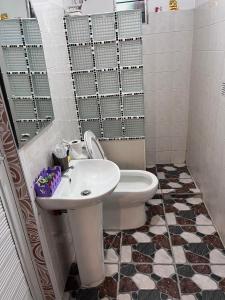 a bathroom with a white toilet and a sink at Dimbar Tech in Pasong Mannga