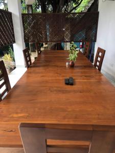 une longue table en bois avec une plante en pot dans l'établissement Senanayaka Holiday Inn, à Polonnâruvâ