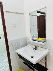 Baño blanco con lavabo y espejo en MOTEL CASON en Chau Doc