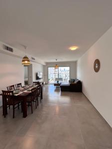 a dining room and living room with a table and chairs at Sea Breeze Netanya Retreat by Sea N' Rent in Netanya
