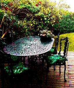 a table and a chair sitting on a patio at Sherwood Garden Cottage in Durban