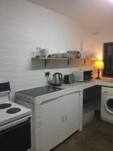 a kitchen with a counter with a stove and a sink at Sherwood Garden Cottage in Durban