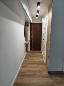 corridoio di un corridoio con porta e pavimento in legno di VirginRoom a Kielce