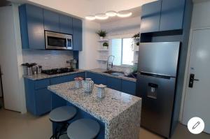 a kitchen with blue cabinets and a counter with a refrigerator at Oceano 21 in Tijuana