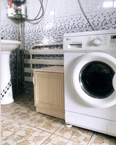 uma máquina de lavar roupa na casa de banho com um lavatório em Guest house В гостях у Лаззат em Türkistan