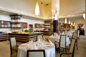 a restaurant with white tables and chairs and a buffet at Flamingo Grand Hotel & Spa in Albena