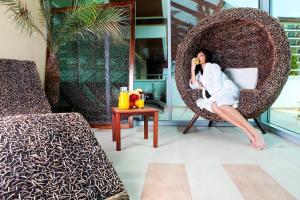 a woman sitting in a chair talking on a cell phone at Flamingo Grand Hotel & Spa in Albena