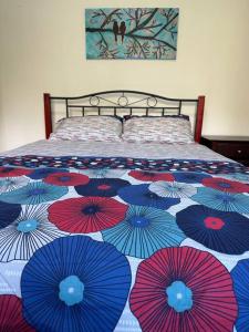 a bed with red and blue umbrellas on it at 3 BDR house close to train station, airport & City in Sydney