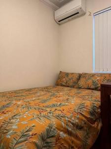 a bedroom with a bed with a comforter on it at 3 BDR house close to train station, airport & City in Sydney